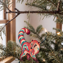 Load image into Gallery viewer, Laser-cut maple wood Coati folk art ornament O408 hanging on a fir branch, made in USA
