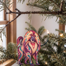 Load image into Gallery viewer, Laser-cut maple wood Gelada folk art ornament O420 hanging on a fir branch, made in USA
